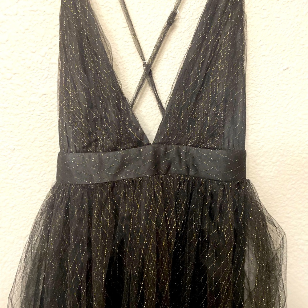 Black low cut floor length dress. made of tool. Gold sparkle design. low cut.